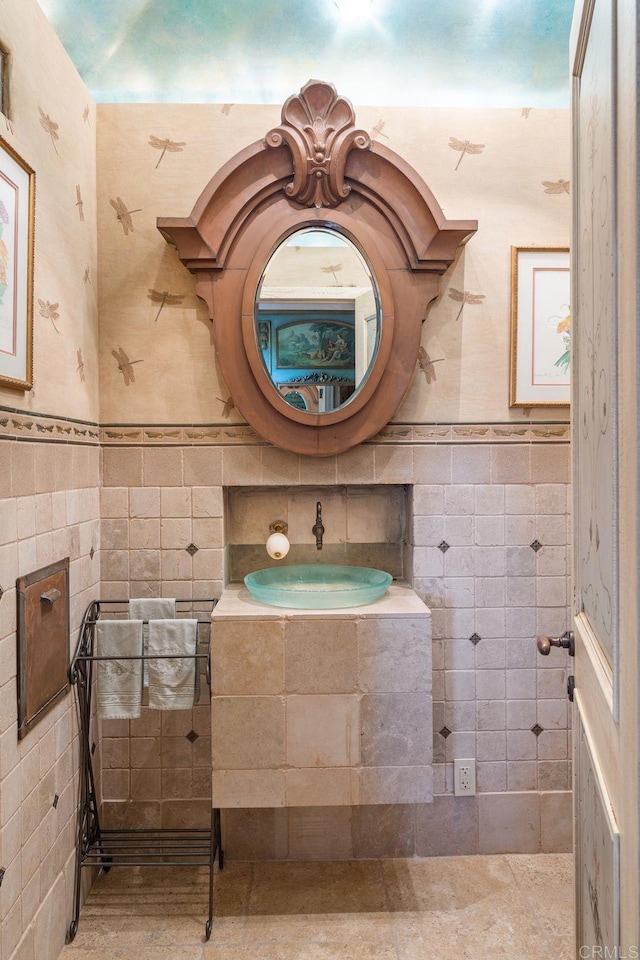 bathroom with sink and tile walls