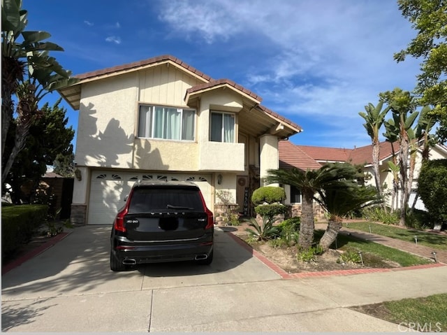 view of front of house with stucco siding, driveway, a tile roof, and a garage