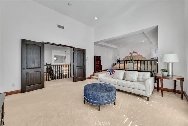 living room with carpet flooring and a towering ceiling