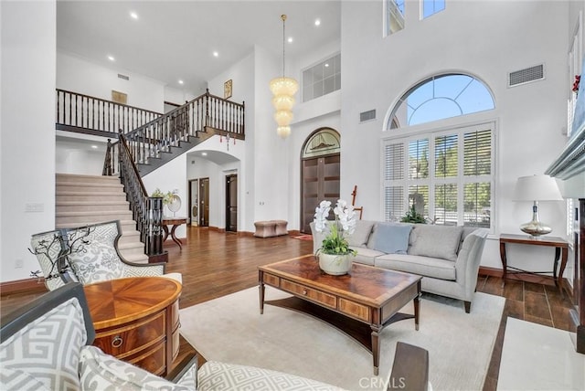 living room with hardwood / wood-style flooring and a towering ceiling