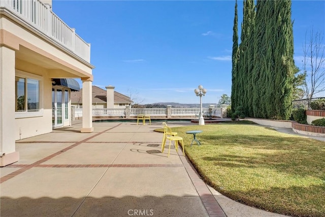 view of property's community with a lawn and a patio