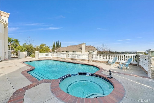 view of swimming pool featuring an in ground hot tub and a patio area