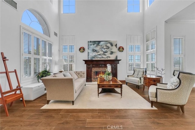 sitting room with a towering ceiling, ornamental molding, and a wealth of natural light