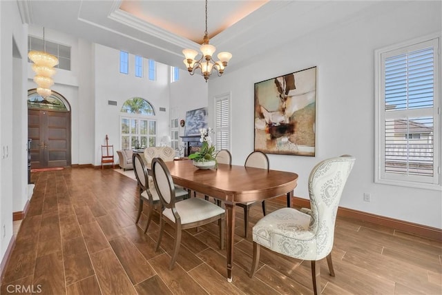 dining space with a raised ceiling and a chandelier