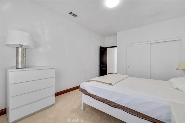 bedroom featuring light colored carpet and a closet