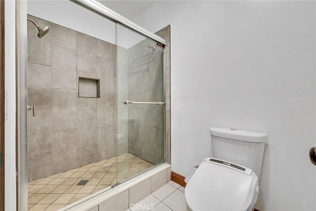 bathroom with tile patterned floors, a shower with shower door, and toilet