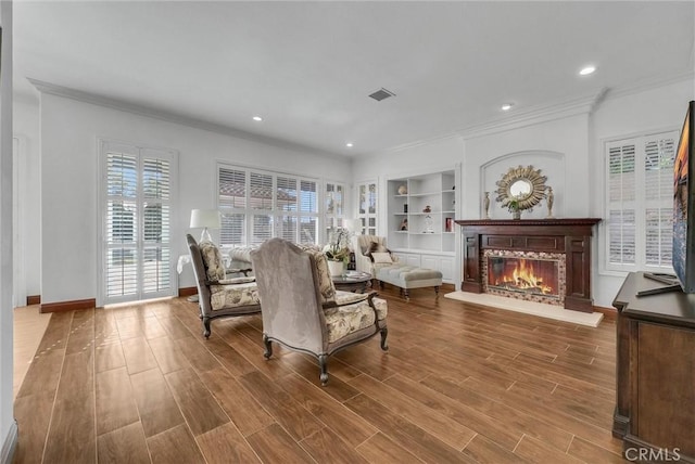 living room featuring built in features and ornamental molding