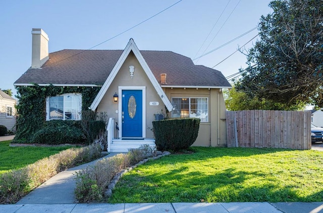 english style home featuring a front yard