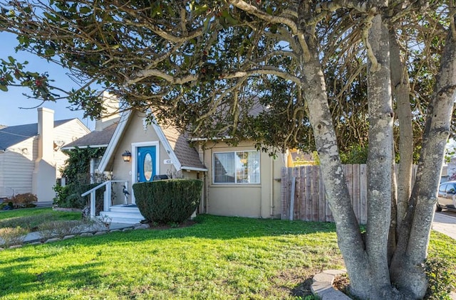 view of property hidden behind natural elements featuring a front yard