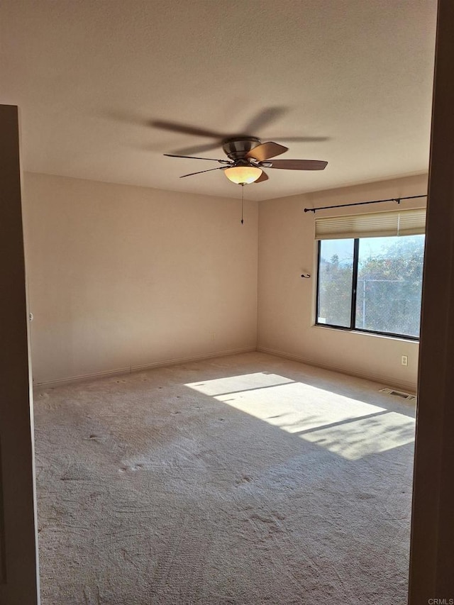 spare room featuring carpet and ceiling fan