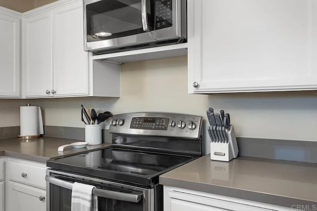 kitchen featuring stainless steel appliances and white cabinetry