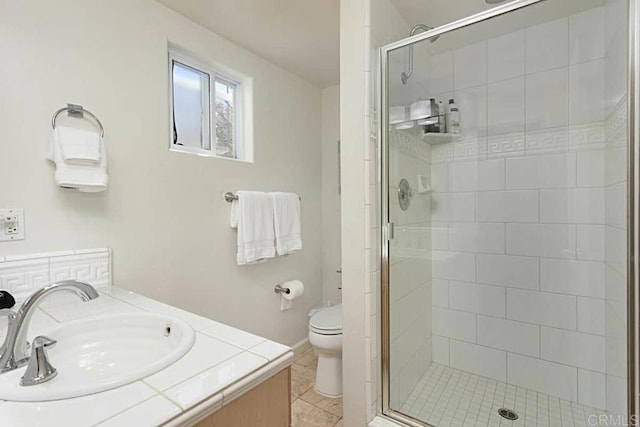 bathroom with tile patterned floors, toilet, vanity, and an enclosed shower