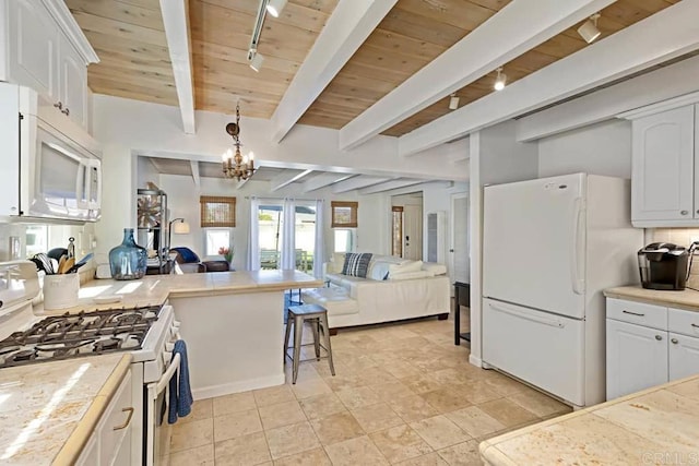 kitchen with white appliances, white cabinets, and track lighting