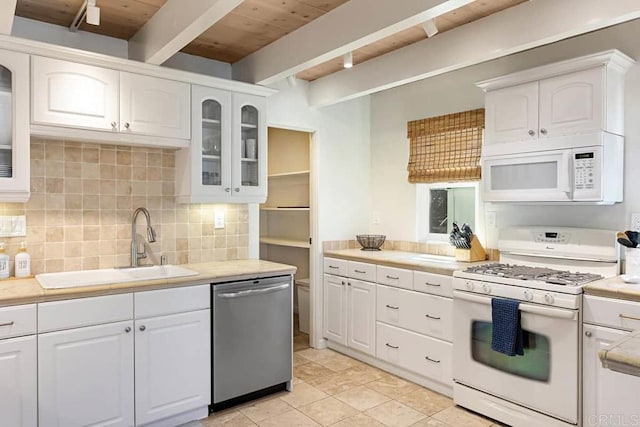 kitchen with beam ceiling, sink, white appliances, white cabinets, and wooden ceiling