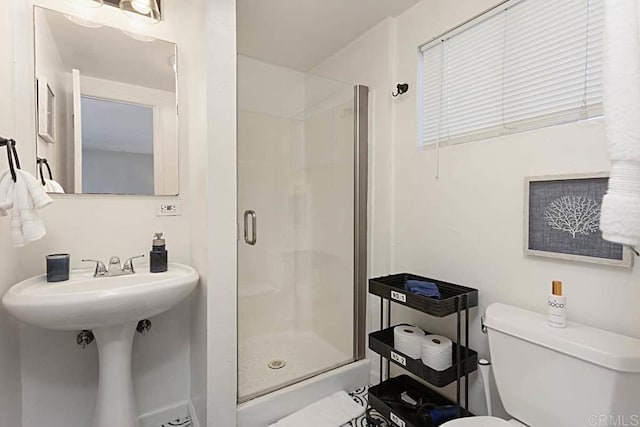 bathroom featuring toilet and an enclosed shower