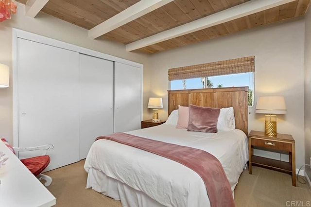 bedroom featuring light carpet, a closet, beamed ceiling, and wooden ceiling