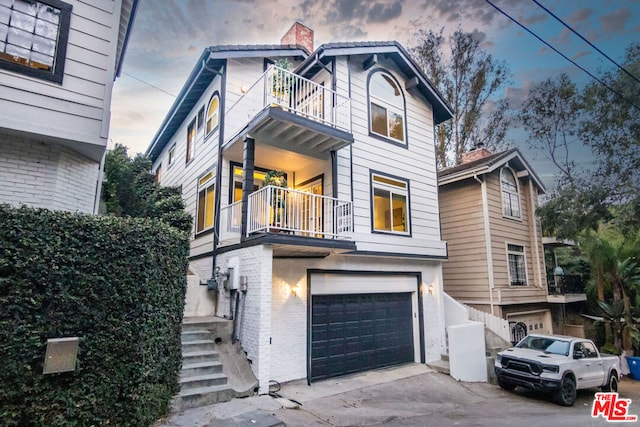 view of front of home with a balcony and a garage