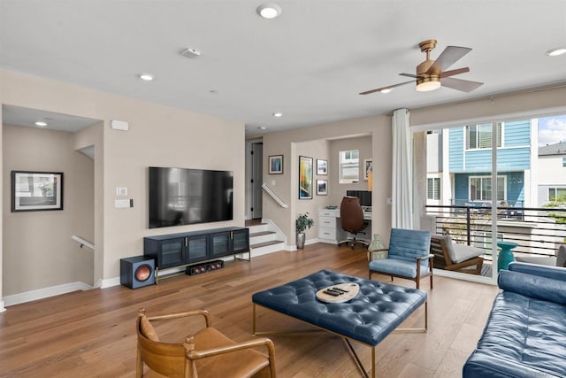 living room with ceiling fan and light hardwood / wood-style flooring