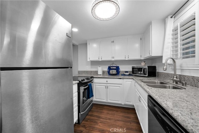 kitchen featuring sink, light stone countertops, dark hardwood / wood-style flooring, white cabinetry, and stainless steel appliances