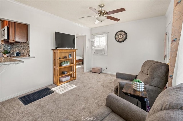 living room featuring cooling unit, light carpet, ornamental molding, and ceiling fan