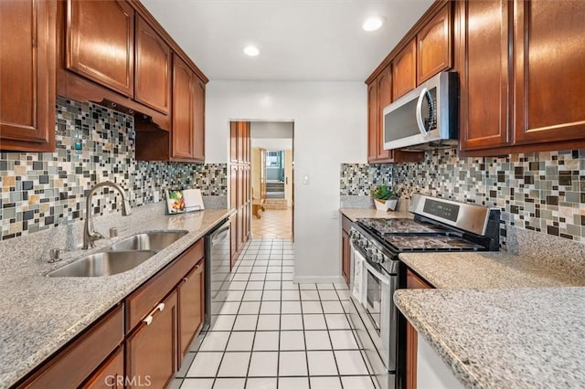 kitchen featuring stainless steel appliances, sink, light tile patterned floors, and tasteful backsplash