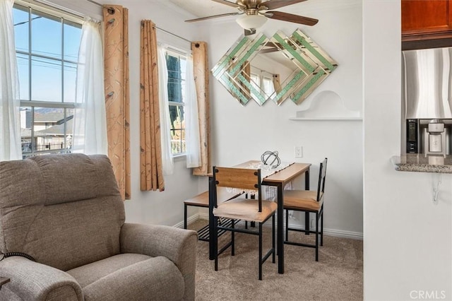 sitting room with ceiling fan, light colored carpet, and plenty of natural light