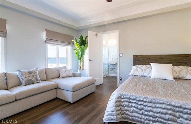 bedroom featuring a water view, dark hardwood / wood-style flooring, and connected bathroom