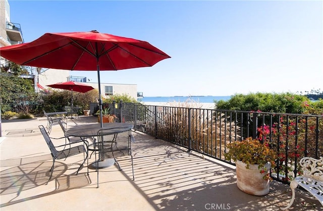 view of patio featuring a beach view and a water view