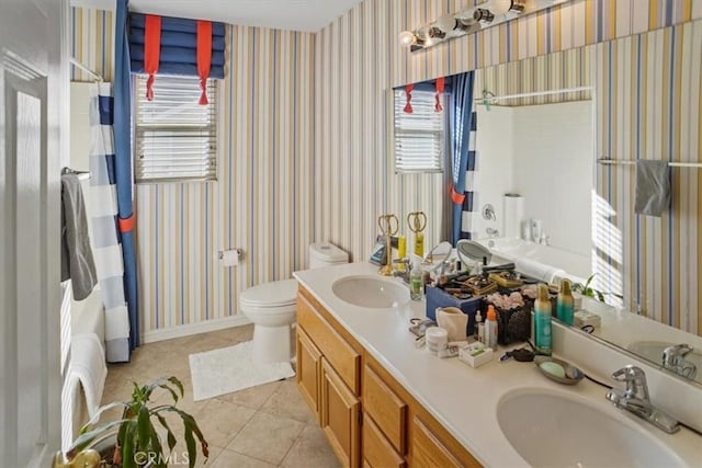 bathroom with toilet, vanity, and tile patterned floors