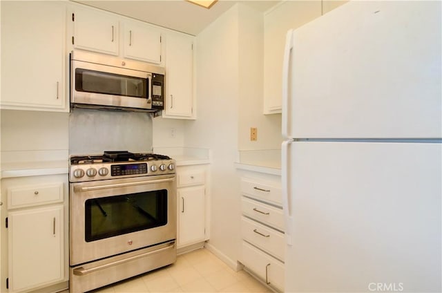 kitchen featuring light tile patterned floors, stainless steel appliances, and white cabinetry