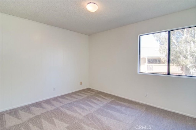 carpeted empty room with a textured ceiling