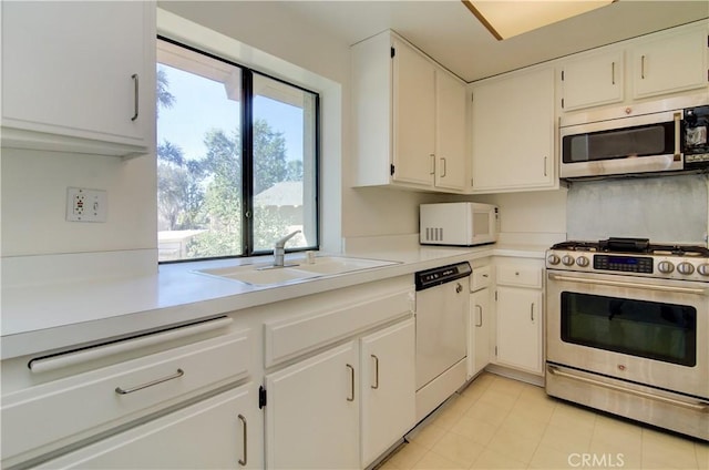 kitchen with plenty of natural light, appliances with stainless steel finishes, white cabinetry, and sink