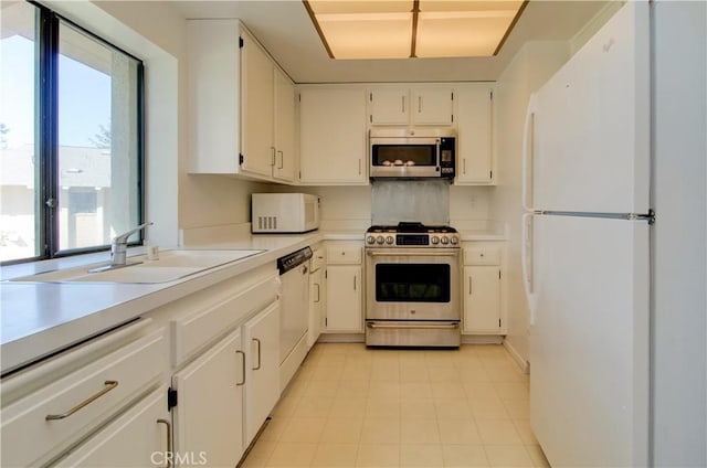 kitchen with white cabinets, a wealth of natural light, appliances with stainless steel finishes, and sink