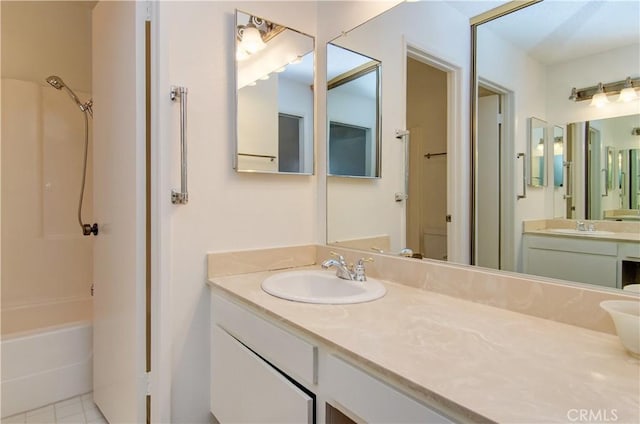 full bathroom with toilet, vanity, tile patterned floors, and washtub / shower combination