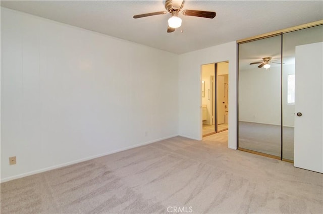 unfurnished bedroom featuring ceiling fan, a closet, and light carpet