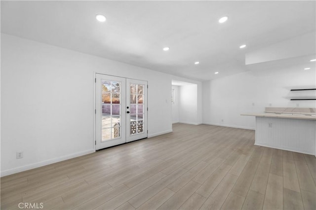 unfurnished living room with french doors and light hardwood / wood-style floors