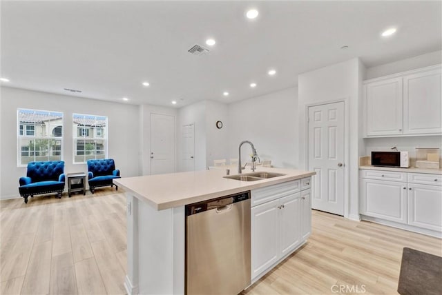 kitchen with sink, white cabinets, dishwasher, light hardwood / wood-style floors, and a center island with sink