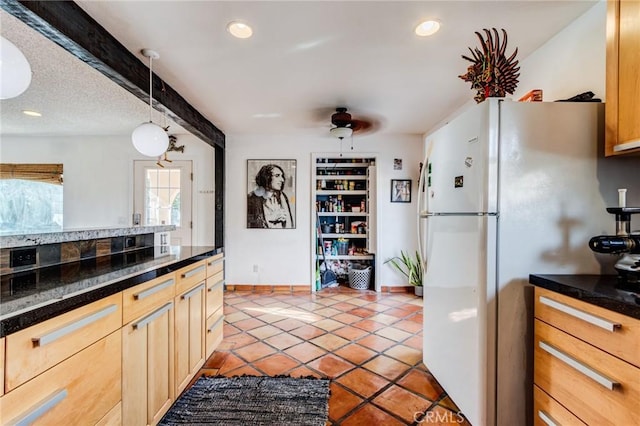 kitchen with pendant lighting, white fridge, light brown cabinetry, light tile patterned floors, and ceiling fan