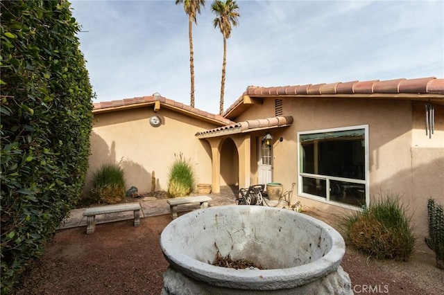 rear view of house with an outdoor fire pit and a patio