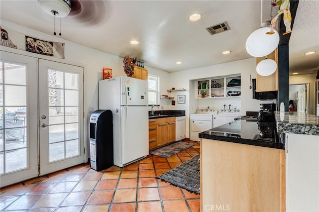 kitchen featuring white appliances, kitchen peninsula, french doors, light tile patterned floors, and washing machine and clothes dryer