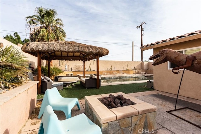 view of patio with a gazebo, a swimming pool, and an outdoor living space with a fire pit