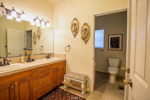 bathroom with tile patterned flooring, vanity, and toilet