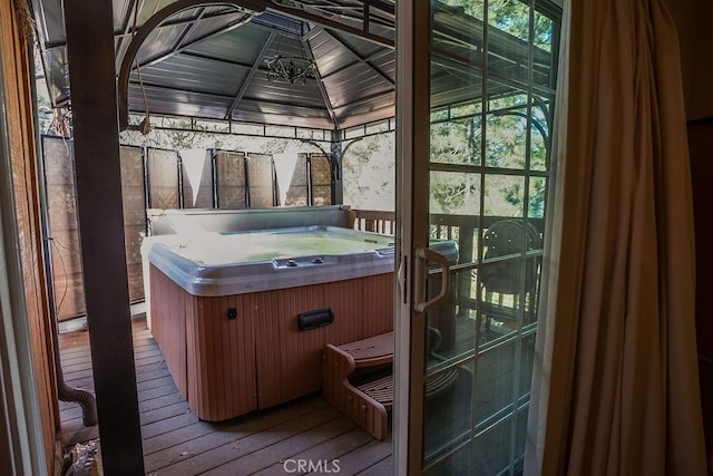 wooden terrace with a gazebo and a hot tub