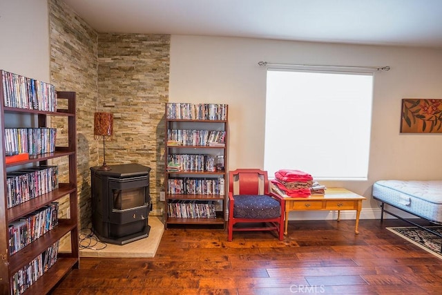 living area featuring dark hardwood / wood-style flooring and a wood stove