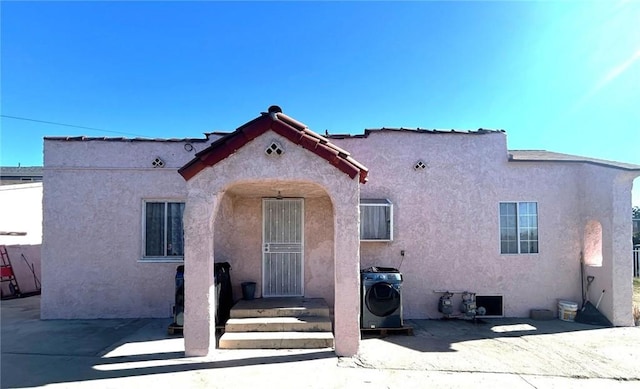 view of front of house featuring washer / dryer and a patio