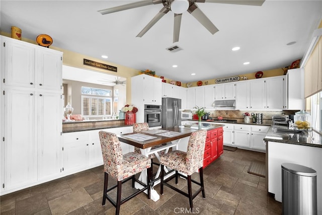 kitchen with white cabinets, stainless steel appliances, and backsplash