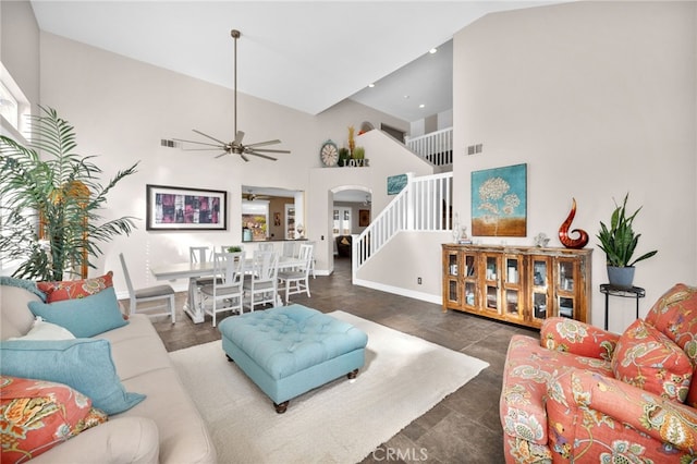 living room with a high ceiling and ceiling fan