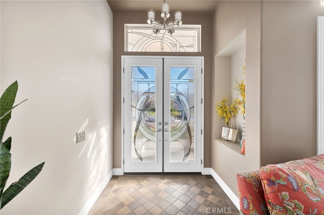 entryway featuring french doors and a chandelier