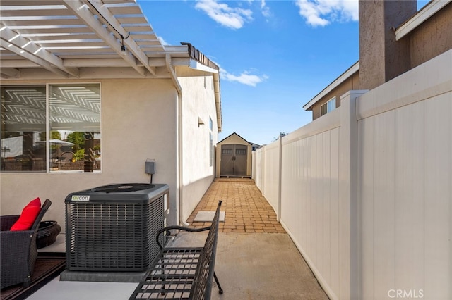 view of patio / terrace with a pergola, central air condition unit, and a storage shed