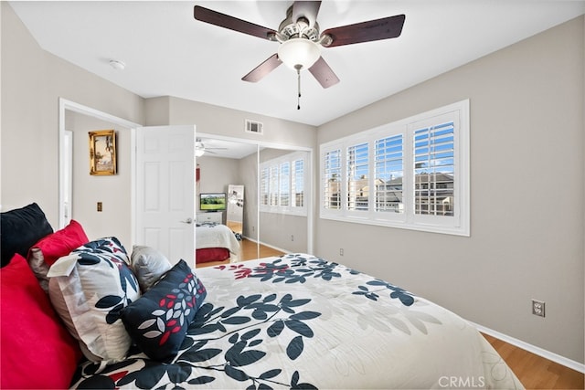 bedroom with ceiling fan, a closet, and wood-type flooring